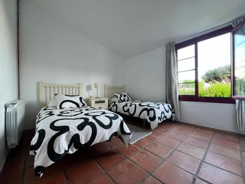 a bedroom with two beds with black and white sheets at Finca Abejera in La Orotava