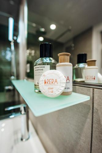 two bottles of alcohol sitting on a shelf in a bathroom at Brera Serviced Apartments Böblingen Sindelfingen in Böblingen