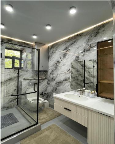 a bathroom with a shower and a sink and a toilet at Атлантис Резорт in Chon-Sary-Oy