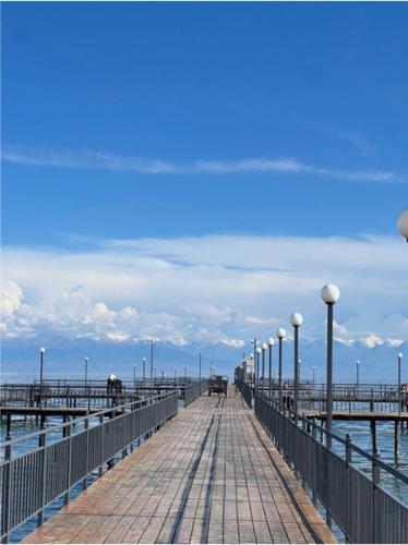 a boardwalk leading to a pier in the water at Атлантис Резорт in Chon-Sary-Oy