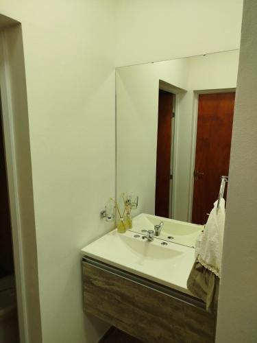 a bathroom with a sink and a large mirror at Quinta El sol in Reconquista