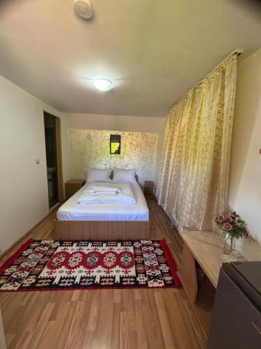 a bedroom with a bed and a rug on the floor at Pensiunea Anca Sapanta-primeste carduri de vacanta in Săpînţa