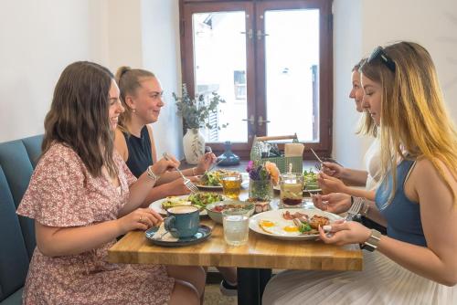a group of women sitting around a table eating food at Vlaštovčí dům in Nové Město nad Metují