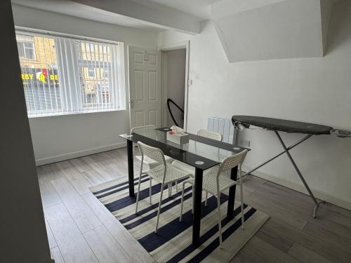 a dining room with a glass table and chairs at Sowerby apartments in Sowerby Bridge