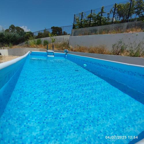 une piscine bleue avec de l'eau bleue dans l'établissement Villa de standing climatisée, piscine & jacuzzi - 20' Cannes, à La Roquette-sur-Siagne