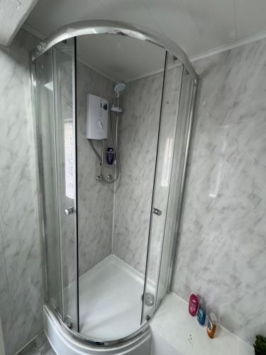 a shower with a glass door in a bathroom at Sowerby apartments in Sowerby Bridge