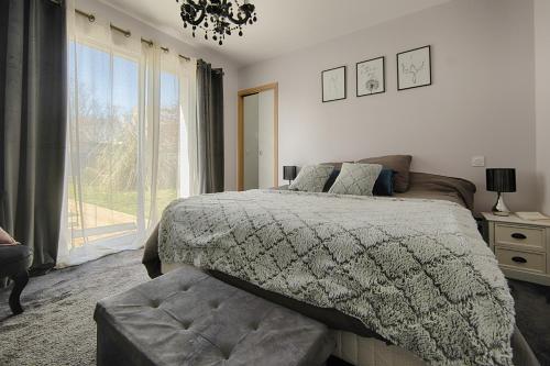 een slaapkamer met een bed en een groot raam bij Maison Landes in Mées