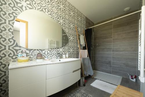 een badkamer met een wastafel en een spiegel bij Maison Landes in Mées