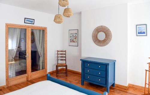 a bedroom with a blue dresser and a chair at 4 Bedroom Cozy Home In Aiguillon in Aiguillon