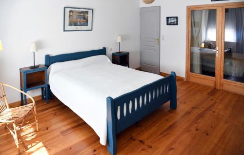 a blue bed in a room with a wooden floor at 4 Bedroom Cozy Home In Aiguillon in Aiguillon