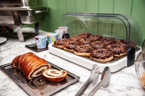 a tray of pastries and a tray of donuts on a counter at Penzion Fortune in Dunajská Streda