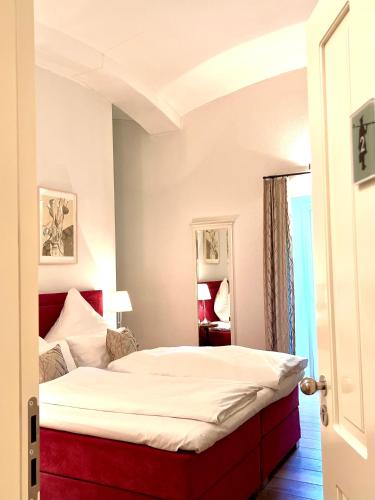 a bedroom with a bed with a red headboard at Nachtquartier Burg Flamersheim in Euskirchen