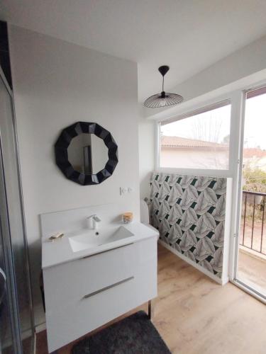 bagno con lavandino e specchio a parete di Plein Sud -Maison proche centre, idéal famille a Montauban