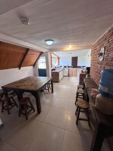 a room with a table and chairs and a kitchen at W i M, Hostel & Camping in Chaupi