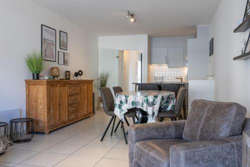 a kitchen and living room with a table and chairs at Volledig gerenoveerd 2 slaapkamer appartement in Westende-Bad, 250 m van het strand in Westende Bad