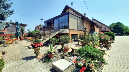 a building with a lot of potted plants at Sarokhaz Panzio in Vecsés