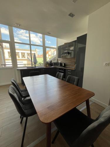 une cuisine avec une table en bois et quelques chaises dans l'établissement La Belle Etoile, à Boulogne-sur-Mer