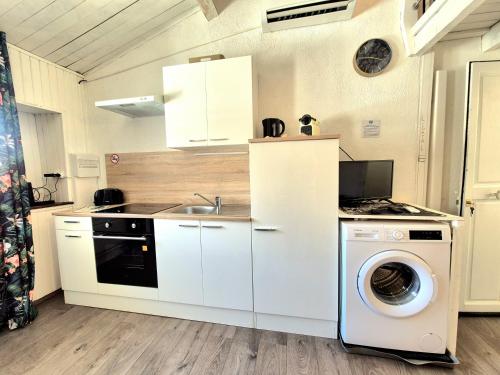 une cuisine avec un lave-linge et un lave-linge dans l'établissement Le petit Nid - coeur de ville - clim, à Nîmes