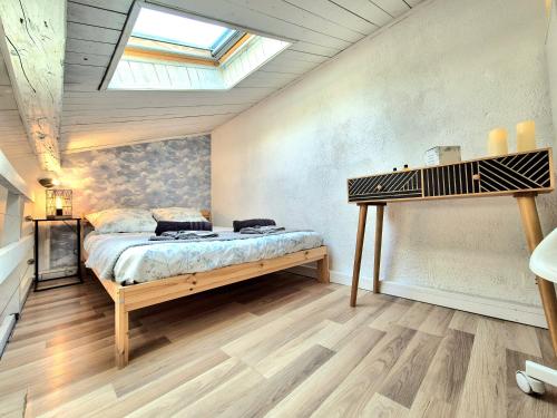 une chambre avec un lit et une lucarne dans l'établissement Le petit Nid - coeur de ville - clim, à Nîmes