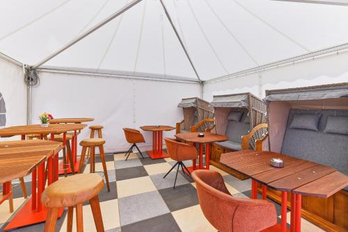 a room with wooden tables and chairs in a tent at Airport-Hotel Fortuna in Lautzenhausen