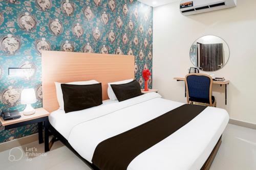 a bedroom with a large bed and a desk with a chair at Hotel Elite rooms & Banquet in Prayagraj