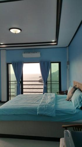 a bedroom with a large bed with a window at Ocean View Resort - Koh Sichang in Ko Si Chang