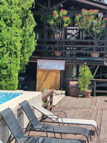 a patio with chairs and a table and a pool at Pension La Ponton in Eşelniţa