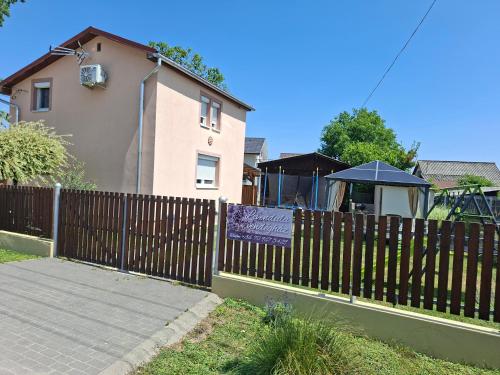 a fence with a sign on it next to a house at Levendula Vendégház in Hajdúnánás