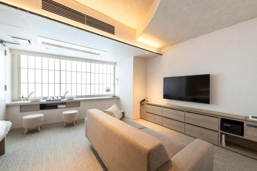 a living room with a couch and a flat screen tv at ENT TERRACE Asakusabashi in Tokyo