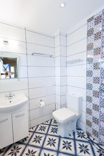 a bathroom with a toilet and a sink at Вила Къщата с рибките in Sinemorets