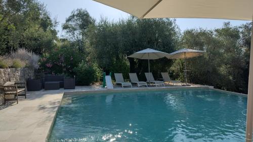une piscine avec des chaises et un parasol dans l'établissement Beautiful private villa with open views, à Valbonne