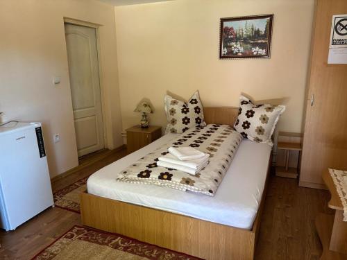 a small bedroom with a bed with towels on it at Pensiunea Anca Sapanta-primeste carduri de vacanta in Săpînţa