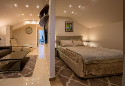 een slaapkamer met een bed en een woonkamer bij Apartmani Tip-Top in Tivat