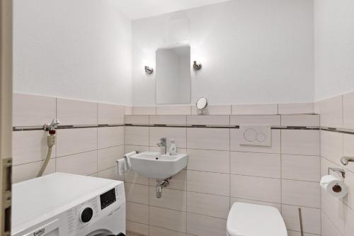 a white bathroom with a sink and a toilet at Reiselust in Stockach