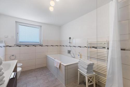 a white bathroom with a tub and a sink at Reiselust in Stockach