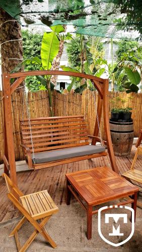 a wooden swing with two chairs and a table at Hotel La Residence Hammamet in Hammamet