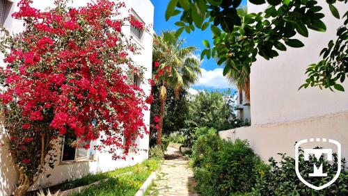 a building with red flowers on the side of it at Hotel La Residence Hammamet in Hammamet