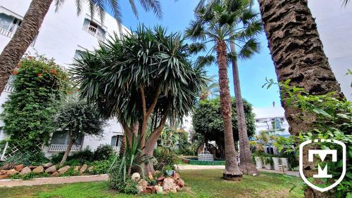 a group of palm trees in front of a building at Hotel La Residence Hammamet in Hammamet