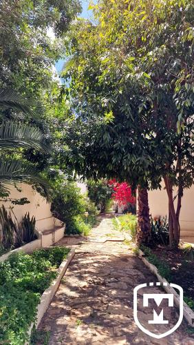 a dirt path with trees and a building at Hotel La Residence Hammamet in Hammamet