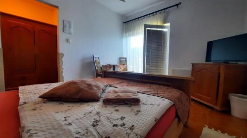 a bedroom with a bed and a flat screen tv at Sarokhaz Panzio in Vecsés