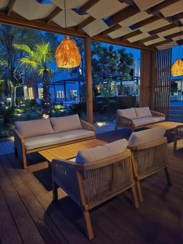 a patio with couches and tables on a deck at The Mini Resort in Prinos
