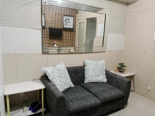 a living room with a couch and a mirror at Sea Residence Tower EF Lets in Manila