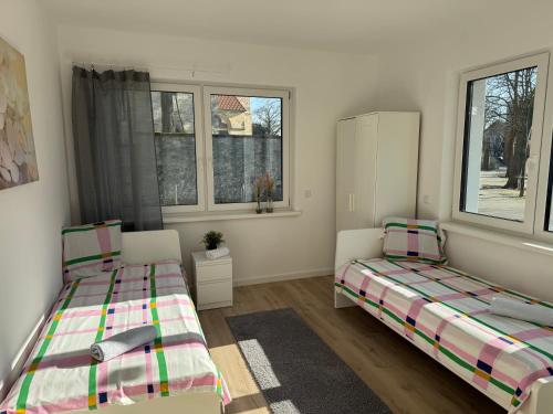 two beds in a room with two windows at Monteurswohnung nahe Münster in Schöppingen
