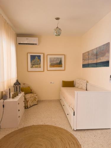 un dormitorio con una cama y un sofá en MonKeys Apartments Sanlúcar Beach Relax, en Sanlúcar de Barrameda