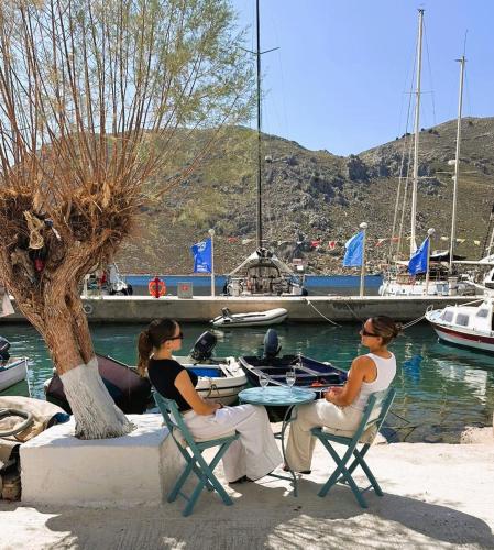 two people sitting at a table near a marina at Seaside House in Symi