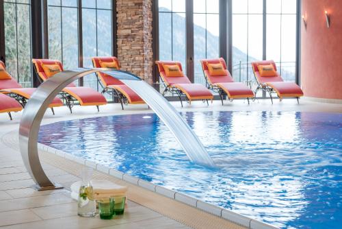basen ze zjeżdżalnią wodną w pokoju hotelowym w obiekcie Gut Berg Naturhotel w mieście Sankt Johann im Pongau