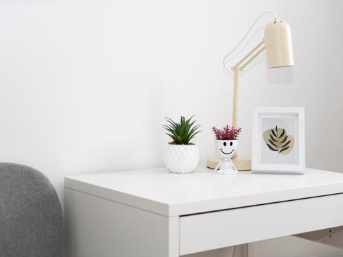a white desk with a lamp and a chair at Lottes Hus in Lübeck