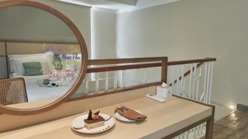 a room with a mirror and a table with a cake at The Allure Villas Managed by Sahid in Pangandaran