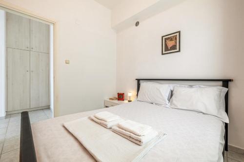 a bedroom with a white bed with towels on it at The Libyan Coast House in Paránimfoi