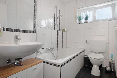 a white bathroom with a sink and a toilet at Geräumige schöne Ferienwohnung in Weingarten